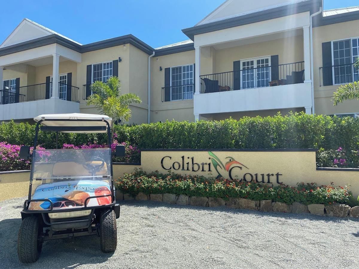 Placa de Colibri Court com um carrinho de golfe na frente.