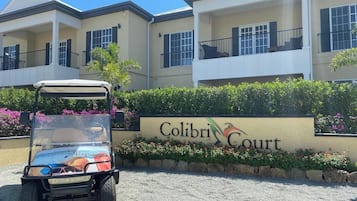 Placa de Colibri Court com um carrinho de golfe na frente.