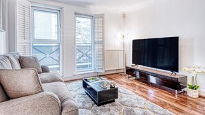 A modern living room with a sofa, a coffee table, a TV, and a radiator. - At Home in Marylebone (London)