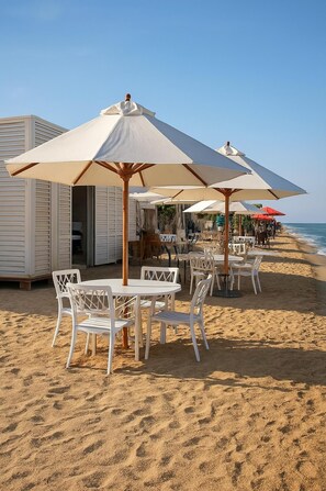 Ein Restaurant am Strand mit Außenplätzen und Sonnenschirmen.
