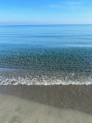 A beach with clear water and a sandy shore.