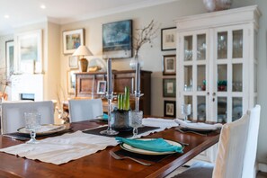 Enjoy a meal in this beautifully set dining area with a wooden table, white napkins, and glassware.