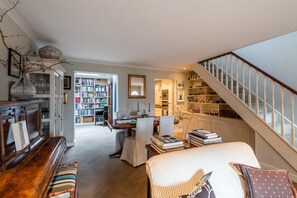 Relax in a cozy living space with a comfortable seating area, dining table, and bookshelf.
