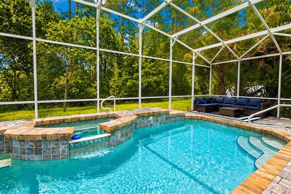 A swimming pool with a tiled edge and a wooden deck surrounding it.