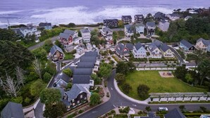 An aerial view of a coastal residential area with houses, roads, and a beach.