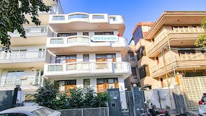 Un edifici de diverses plantes amb balcons, un cartell de 'SKS Excel Inn' i una entrada tancada amb reixa.