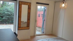 Una habitación con puerta de madera, una mesa negra y una lámpara colgante.