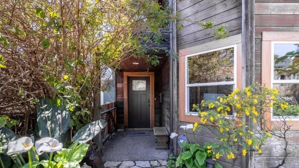 A wooden house with a stone pathway leading to the entrance, surrounded by lush greenery and flowering plants. - Pacifica Storybook Beach House, 2 blocks from beach, pier and golf, 10 min to SF (Pacifica)