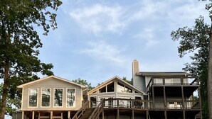 Ein zweistöckiges Haus mit einer Veranda und einer Treppe, die zum Obergeschoss führt.