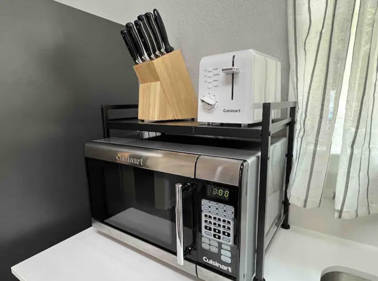 A kitchen with a Cuisinart microwave and toaster on a countertop.