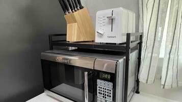 A kitchen with a Cuisinart microwave and toaster on a countertop.