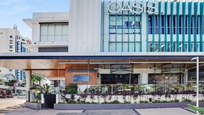 A modern building with a prominent sign reading "OASIS." - Aruba Beach - Private Apartments (Broadbeach)