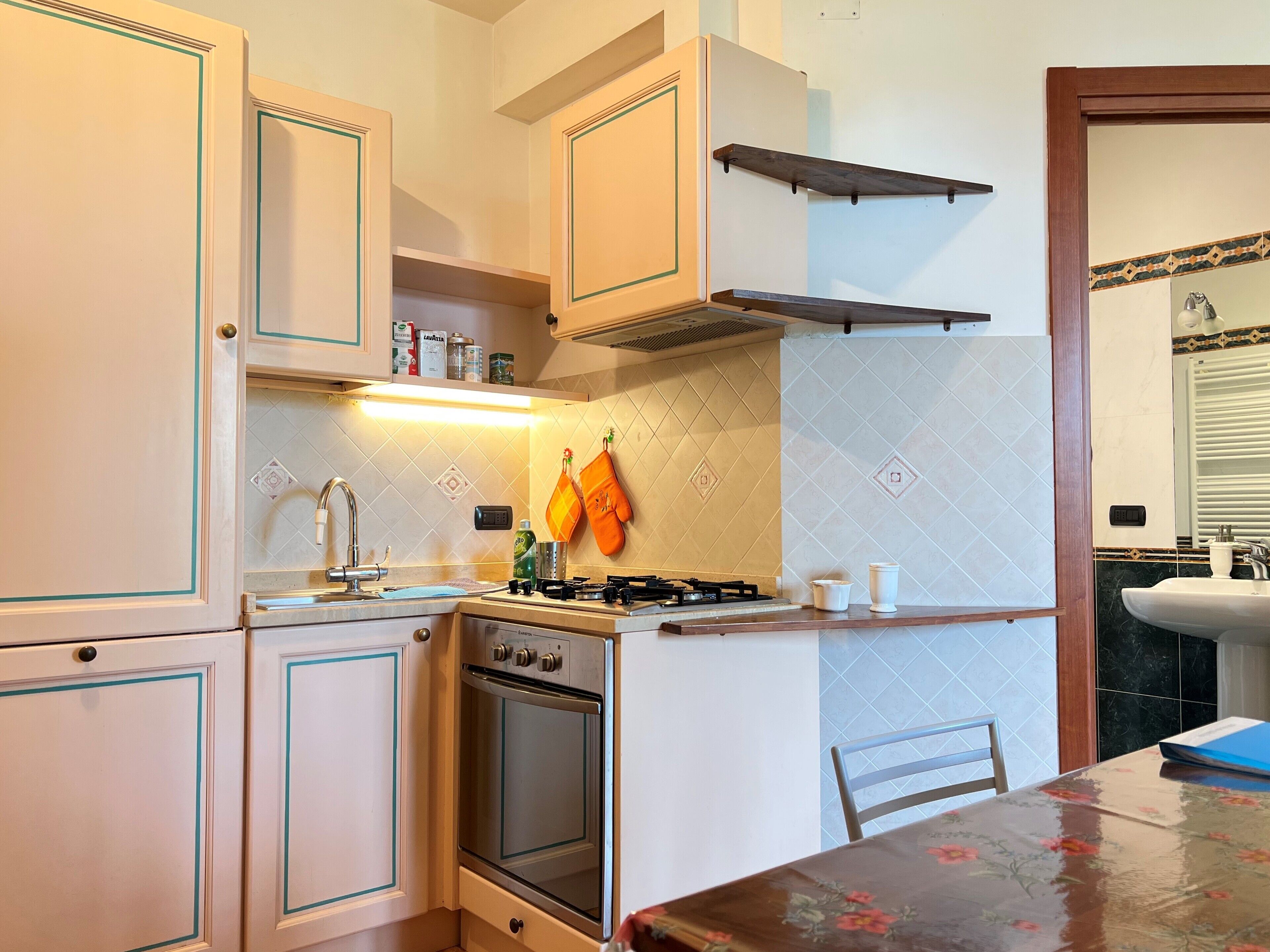A compact kitchen with white cabinets, a gas stove, and a sink.