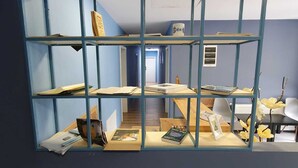 Una habitación con una decoración azul y blanca, que incluye un mueble azul con varios objetos, un escritorio con una silla y una zona de recepción.