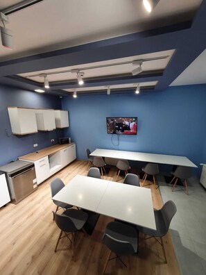 A modern kitchen with a white countertop, built-in appliances, and a large dining table with chairs. - Urban Point (Sfantu Gheorghe)
