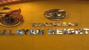 Une enseigne portant l’inscription « BHUVANI HIMALAYAN HEIGHTS » et un logo représentant un oiseau et une montagne.