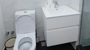Une salle de bain moderne avec des toilettes, un lavabo et un miroir.
