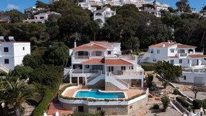 A multi-story building with a pool, surrounded by trees and other buildings. - Villa '49 Son Bou Sunset' with Sea View, Wi-Fi and Air Conditioning (MENORCA)