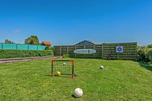 A grassy outdoor area with a goalpost, a target, and a few soccer balls. - Holiday Home 'Villa Léonie – Indoor Pool' with Terrace, Garden, and Wi-Fi (Kerlouan)