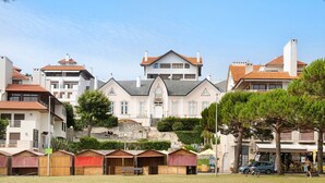 A large, multi-story building with a central entrance, surrounded by smaller structures, possibly guest houses or cottages. - Apartment 'Vista Baia' with Sea View, Shared Pool and Wi-Fi (São Martinho do Porto)