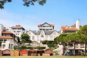 A large, multi-story building with a central entrance, surrounded by smaller structures, possibly guest houses or cottages.