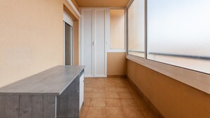 Un estrecho pasillo con un banco, una puerta y una ventana con vistas.