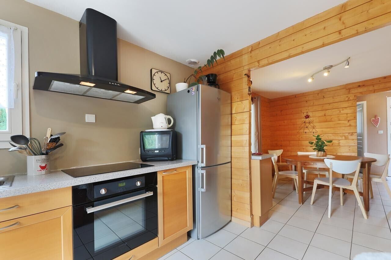 Eine Küche mit Holzwänden, einem Edelstahl-Kühlschrank, einer Mikrowelle und einem Herd.