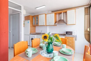 Una cucina compatta con mobili in legno, un forno a microonde e un lavello.