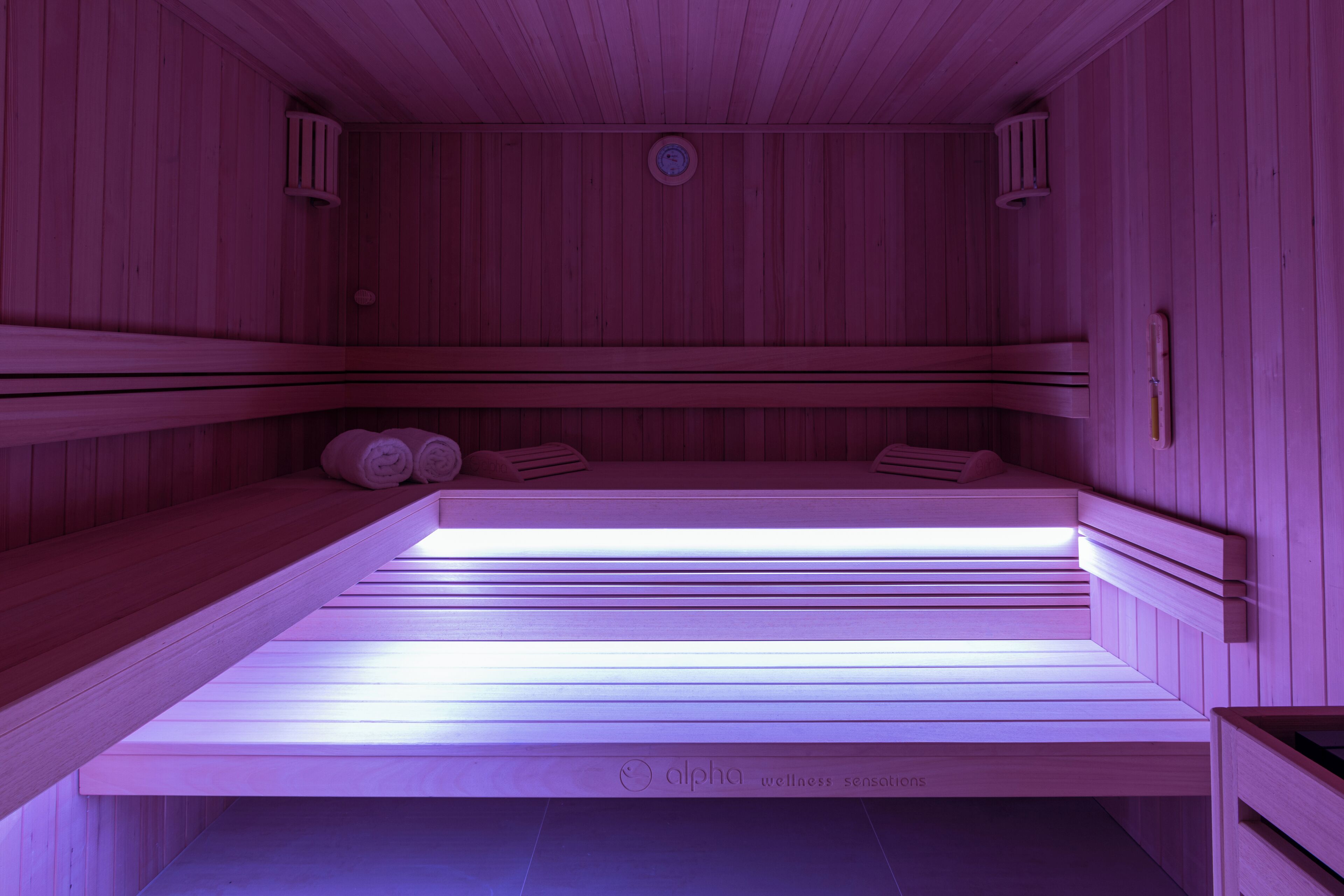 Una sauna in legno con panche e un lettino per massaggi.