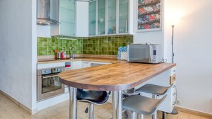 Una cocina con mostrador de madera, microondas y pileta.
