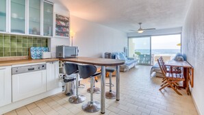 Una cocina con comedor, vistas al mar y un ventilador de techo.