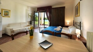 Une chambre d’hôtel avec un lit, un canapé, une table à manger et une vue sur l’extérieur.