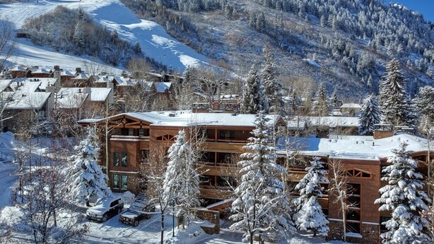 A snow-covered mountain resort with wooden cabins and a ski slope.