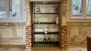 A room with a fireplace, a mirror, and shelves with decorative items. - Charming Artistic and Historic Chartrons Flat with Private Patio
 (Bordeaux)