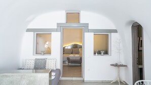 Une chambre moderne avec un grand lit, une petite table et un coin salon.