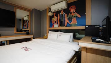 A hotel room with a bed, a desk with a computer, a mirror, and a painting on the wall.