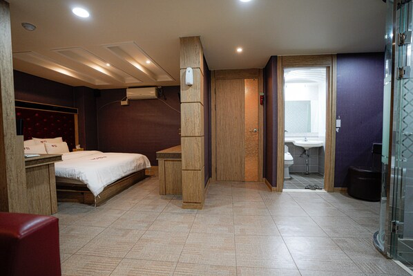 A hotel room with a bed, a desk, a shower, and a bathroom. - Mokpo Well Hotel (Mokpo)