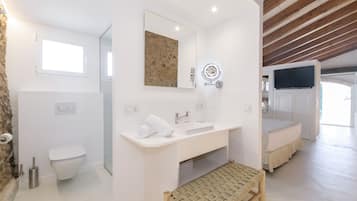 Apartamento superior, 1 habitación, patio, vistas al jardín | Baño | Ducha, cabezal de ducha tipo lluvia, secador de pelo y toallas