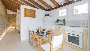 Eine moderne Küche mit Holzbalken, weißen Schränken und einem eingebauten Ofen.