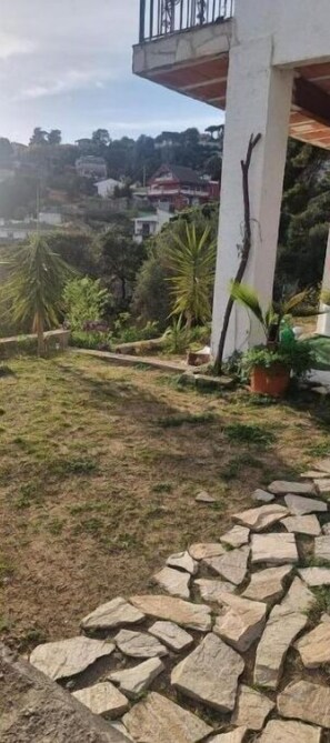 Un sendero de piedra que lleva a un edificio con balcón.