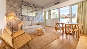 A living room with a sofa, two wicker chairs, a round table, and a large mirror on the wall. - Triana Acacias by Valcambre  (Seville)