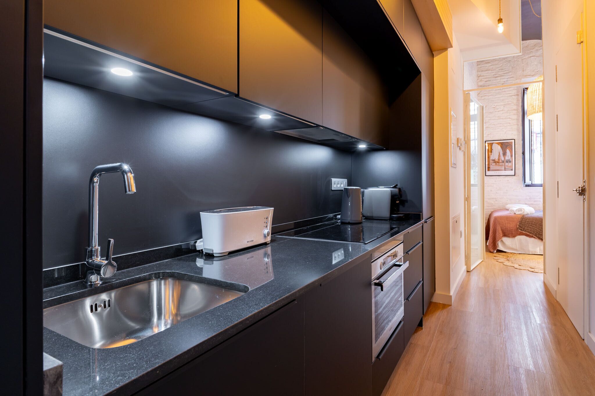 A modern kitchen with a stainless steel sink, a toaster, and a coffee maker.