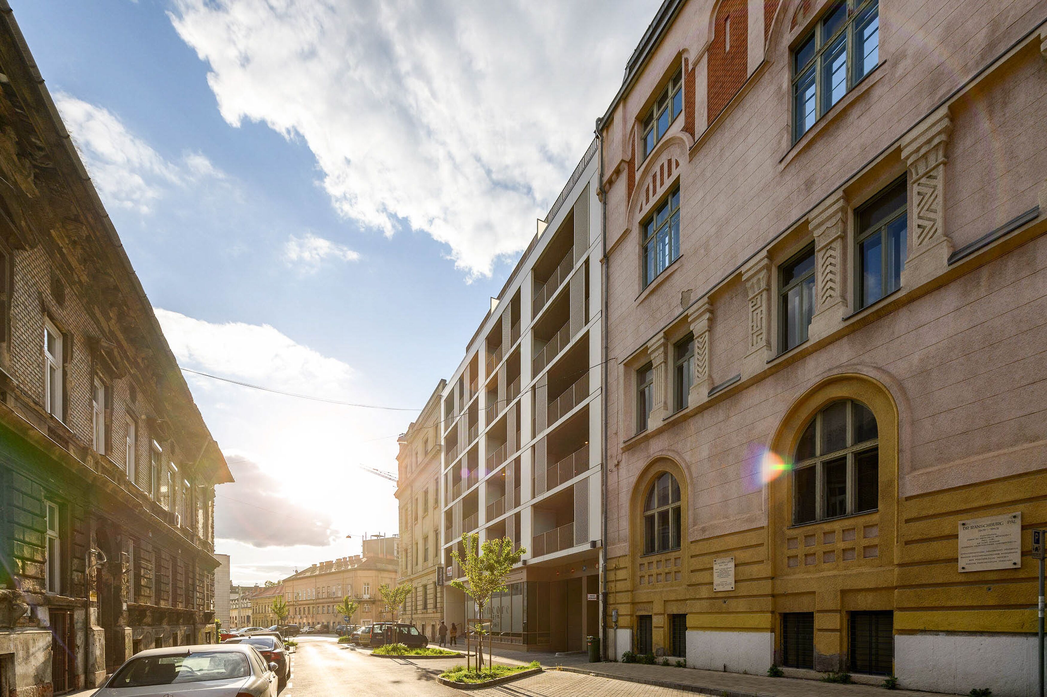 Une vue de rue d’un immeuble dont l’architecture présente un mélange de styles, notamment une fenêtre en arc en saillie et un balcon.