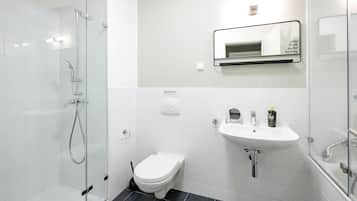 Un bany modern amb dutxa amb envàs de vidre, un vàter blanc, un lavabo i un mirall amb una frase motivacional.