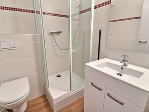 A bathroom with a toilet, a glass-enclosed shower, and a white sink with a mirror. - Comfortable 2 Rooms, Ski-in/Ski-out, 4 People, West Balcony (La Tania)