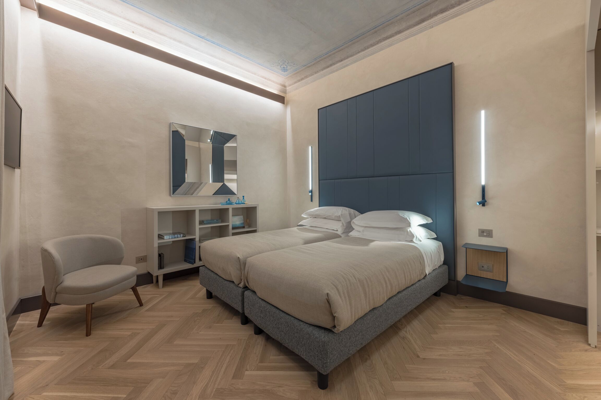 Un dormitorio moderno con una cama grande, una silla, un tocador y un espejo.