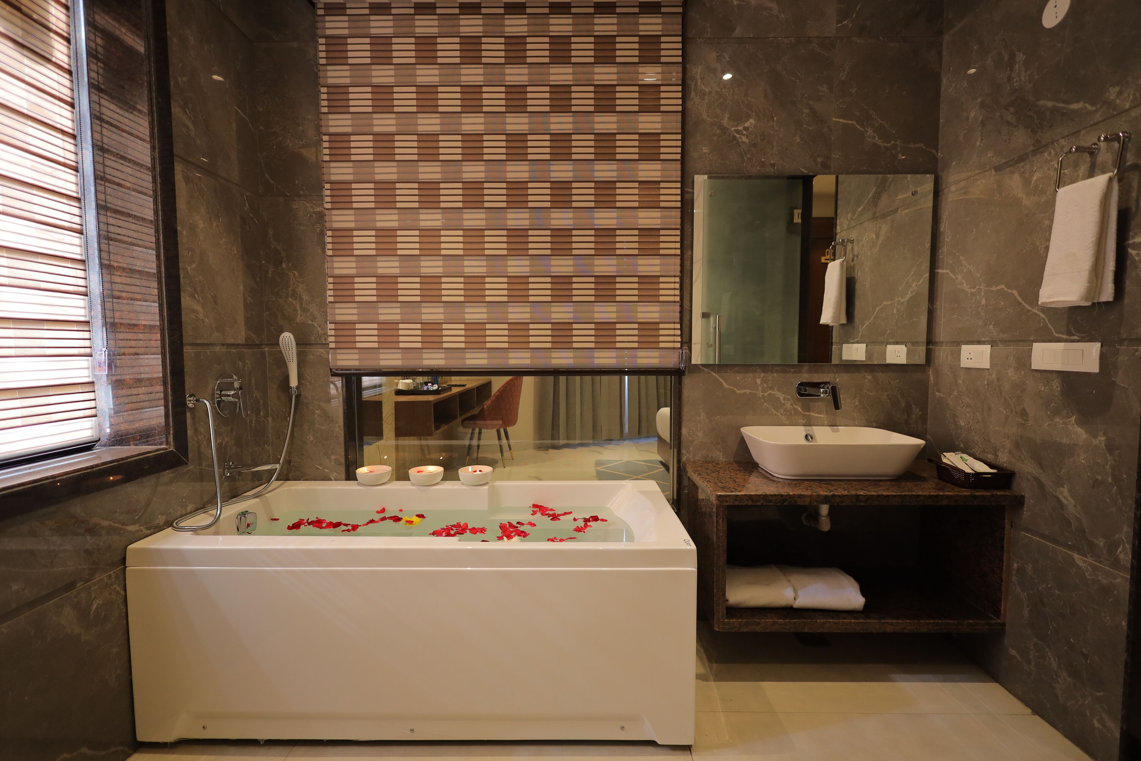 A modern bathroom with a freestanding bathtub, a vanity with a sink, and a large mirror.