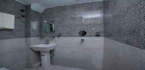 A bathroom with a sink, mirror, and shower. - MeroStay 229 Regency (Kathmandu)