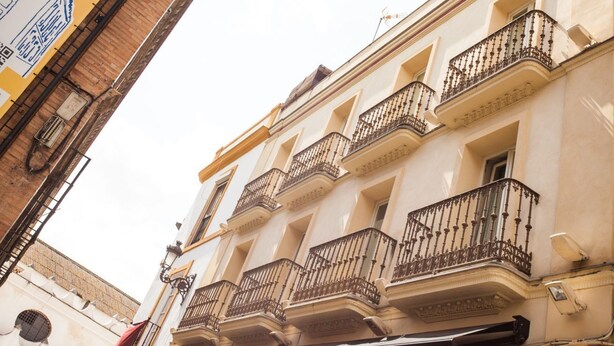 Un bâtiment doté de plusieurs balcons, d’une fenêtre bien visible et d’une porte.