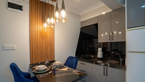 Een moderne keuken met een eettafel, stoelen en een zwart aanrecht.
